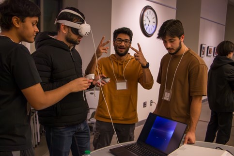 One student with a VR headset. A few students are watching.
