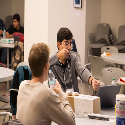 Two students discussing at a laptop.