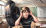Student covering their ears by a speaker