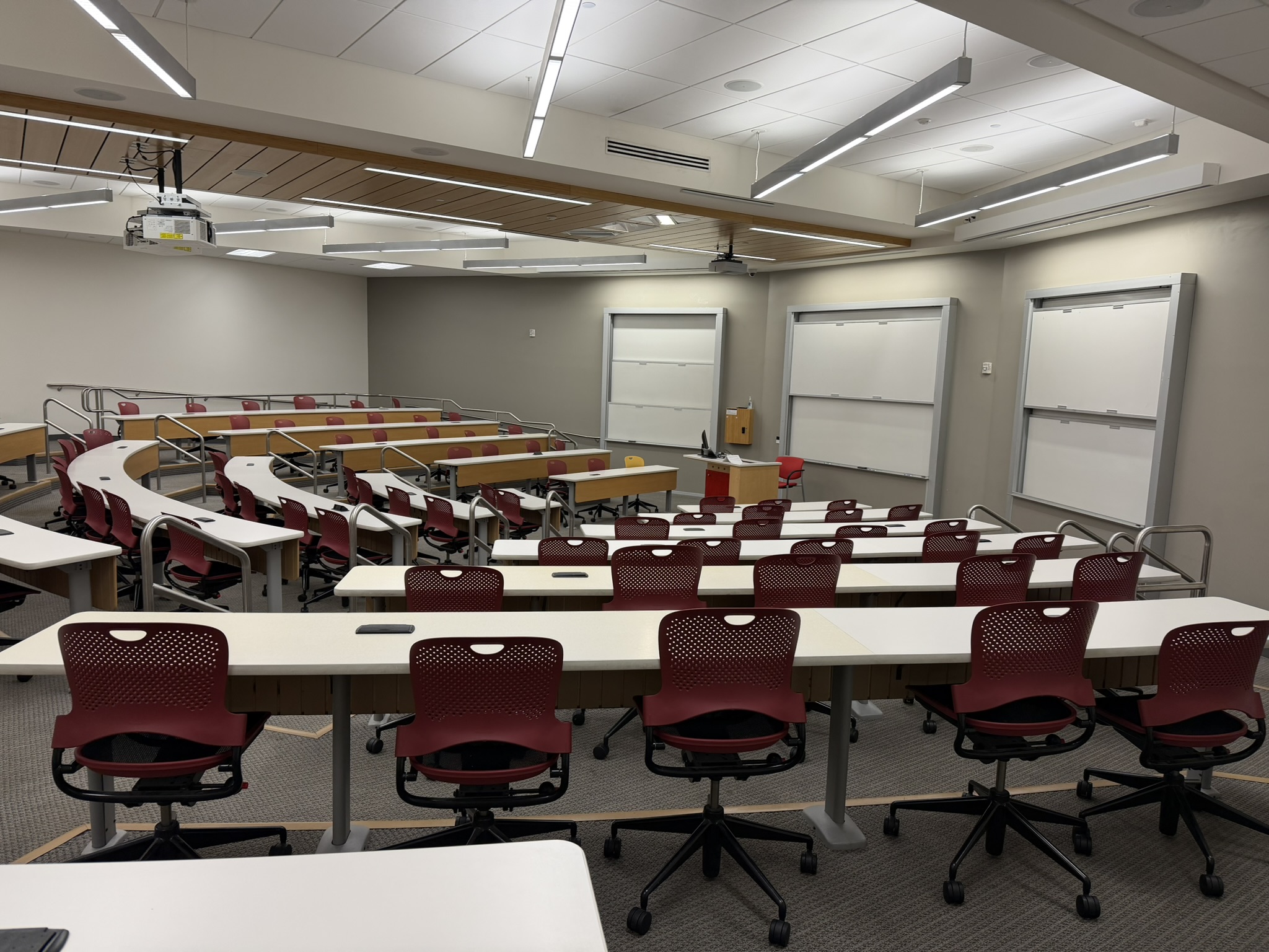 Rows of tables and chairs and two projector screens