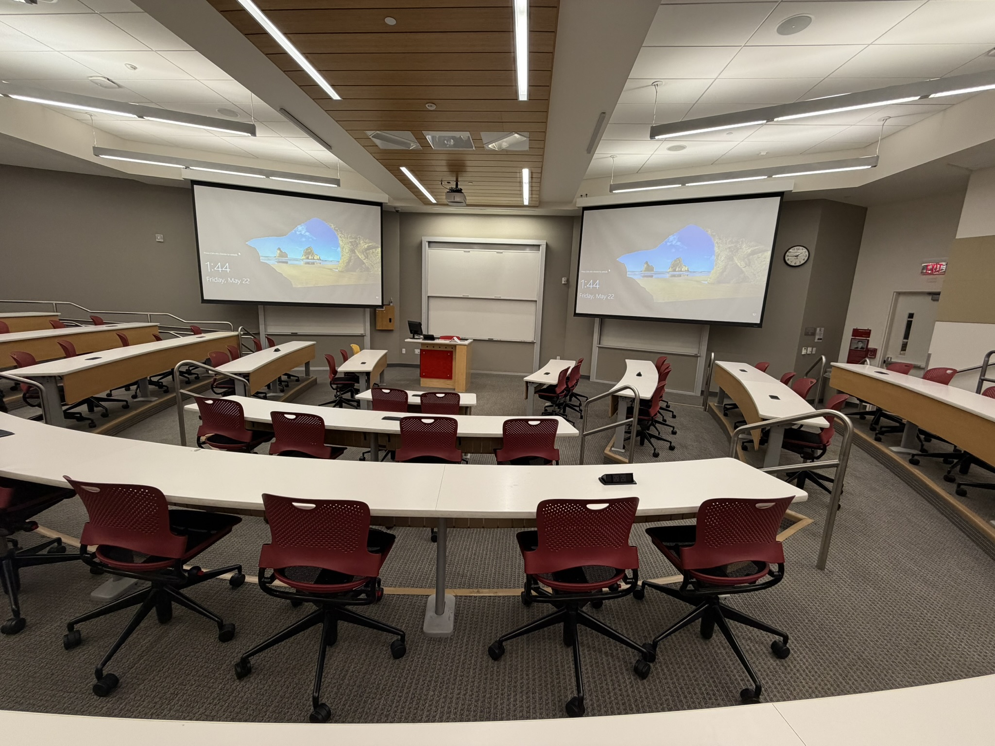 Tiered seats from back with two projector screens