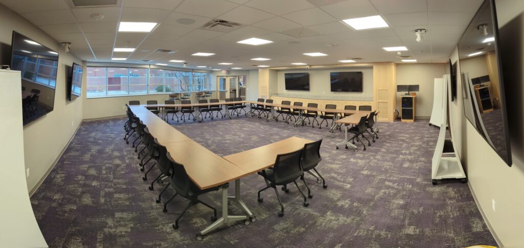 Class space with tables in a square and two displays